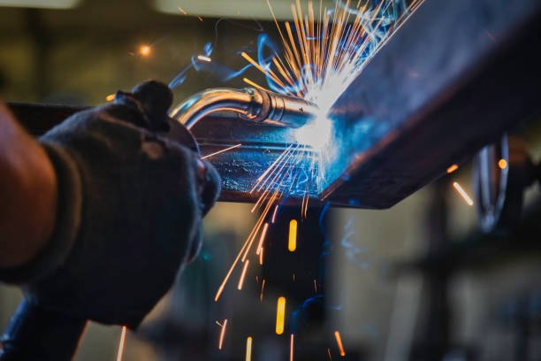 Welded joint on a stainless steel work table frame being dressed smooth